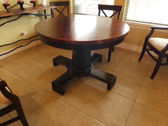 Custom round dining table with copper top and pedestal base