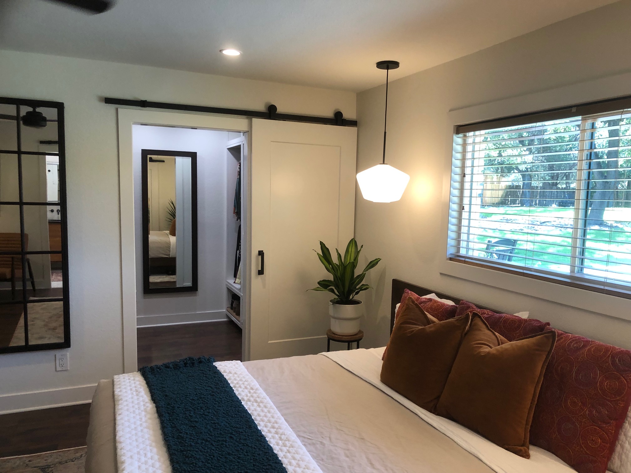 Modern bedroom with barn door and stylish pendant light design
